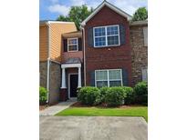 Charming multi-level townhome featuring a brick facade and manicured landscaping at 2612 Haligan Pt, Riverdale, GA 30296