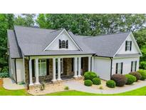 Charming home featuring stone accents, a covered porch with stately columns, and professional landscaping at 7037 Tara Dr, Villa Rica, GA 30180