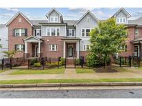 Charming townhome featuring a brick facade, black wrought iron fence, and meticulously maintained landscaping at 2734 Bell Se Dr, Smyrna, GA 30080