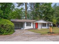 Charming single-story home with a vibrant red front door, driveway, and a well-maintained lawn at 4922 Glenside Ct, Stone Mountain, GA 30088