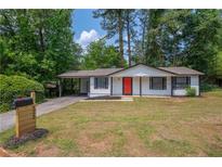 Charming single-story home with a well-maintained lawn, a mailbox and a vibrant red front door at 4922 Glenside Ct, Stone Mountain, GA 30088