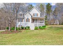 Charming two-story home featuring a quaint front porch and nicely landscaped yard at 76 Riverbend Trl, Douglasville, GA 30134