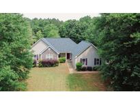 Charming home nestled among mature trees and lush landscaping at 940 Sandy Ford Rd, Social Circle, GA 30025