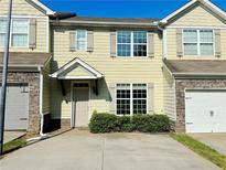 Charming townhome featuring stone accents, inviting entrance, and attached garage, perfect for modern living at 4397 Stone Gate Way, Atlanta, GA 30344