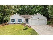 Charming single-Gathering home with a two-car garage, blue shutters, and mature landscaping at 506 Bluff Ct, Woodstock, GA 30188