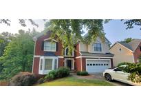 Charming two-story brick home with a well-manicured lawn and an attached two-car garage at 1033 Hawk Creek Trl, Lawrenceville, GA 30043