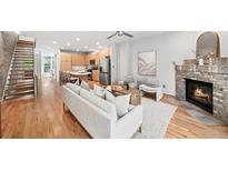 Open-concept living room with a fireplace, wood floors, and staircase to the upper level at 1344 Fernwood Ne Cir, Brookhaven, GA 30319