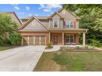 Charming two-story home boasts a well-manicured lawn, brick accents, and an inviting front porch at 224 Farm Manor Ct, Lawrenceville, GA 30045