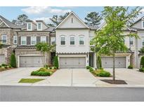 Beautiful townhome featuring a brick facade and a two-car garage with manicured landscaping at 20056 Windalier Way, Roswell, GA 30076