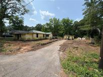 Exterior view of a yellow house with a detached shed and a driveway at 3700 Moore Rd, Austell, GA 30106