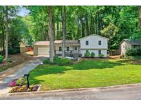 Charming two-story home with a well-manicured front yard and inviting front porch in a beautiful, wooded setting at 5341 Tall Oak Dr, Marietta, GA 30068