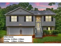 Charming split-level home with a two-car garage, gray siding, and manicured front yard at 240 Mountain Ln, Covington, GA 30016