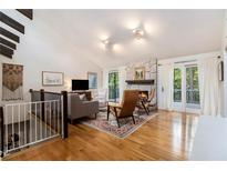 Inviting living room featuring a stone fireplace, hardwood floors, and natural light from the sliding glass doors at 2960 Cedar Knoll Dr, Roswell, GA 30076