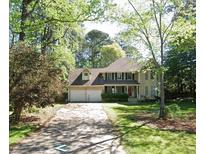 Charming two-story home with a two-car garage, well-manicured lawn, and beautiful surrounding trees at 542 Banks E Rd, Fayetteville, GA 30214