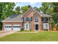 Charming two-story brick home featuring a manicured lawn, attached two-car garage and mature trees at 863 Fairlong Nw Way, Acworth, GA 30101