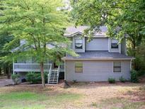 Charming two-story home featuring a cozy porch, gray siding, and lush greenery at 219 Park Avenue, Woodstock, GA 30188