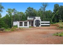 Modern home with geometric design, clean lines, and minimalist aesthetic set in a wooded lot at 5210 Brownlee Rd, Stone Mountain, GA 30087