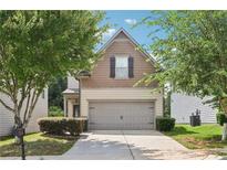Charming home featuring a two-car garage and a well-maintained lawn, surrounded by lush greenery at 72 Fern Walk, Lawrenceville, GA 30045
