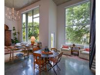 Bright living room featuring large windows, chandelier, and a seating area with a round table and concrete floors at 850 Ralph Mcgill Ne Blvd # 6, Atlanta, GA 30306