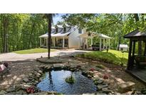Charming home featuring a relaxing pond and a convenient carport with a star accent at 291 Miquel Jorge Ln, Canton, GA 30115