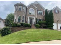 Charming brick home features a well-manicured lawn and an inviting entrance with manicured shrubs at 3717 Shady Maple Dr, Stonecrest, GA 30038