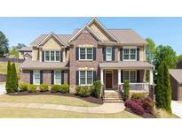 Charming brick two-story home with manicured lawn, established landscaping, and welcoming front porch at 622 Rocky Creek Pt, Woodstock, GA 30188