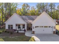 Charming home with white siding, stone accents, and a welcoming front porch with chairs at 728 Harmony Rd, Temple, GA 30179