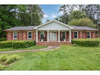 Charming one-story brick home with a large front yard and inviting columned porch at 2808 Peeler Rd, Dunwoody, GA 30360