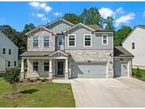 Charming two-story home featuring a stone and gray shingle exterior, complemented by a well-manicured lawn at 776 Clifftop Xing Xing, Powder Springs, GA 30127