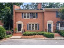 Charming brick townhome featuring a classic facade, black shutters, and landscaped front yard at 3074 Vinings Ridge Se Dr, Atlanta, GA 30339