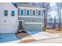 Charming townhome featuring a two-car garage, neutral paint, and a welcoming entrance, perfect for modern living at 174 Bluffington Way, Marietta, GA 30066