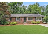 Charming brick ranch with manicured lawn, mature landscaping, and welcoming front entrance at 286 Indian Trl, Marietta, GA 30068