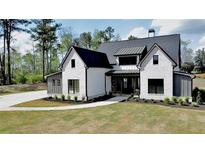 Stunning two-story home boasts a modern farmhouse design with black trim and a manicured front lawn at 115 Palisade Dr, Rydal, GA 30171