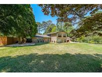 Spacious brick home featuring a large, well-maintained lawn and mature trees at 3530 Embry Circle Cir, Atlanta, GA 30341