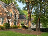 Charming brick home with a manicured lawn, lush landscaping, and a welcoming entrance at 365 Falling Creek Bnd, Duluth, GA 30097