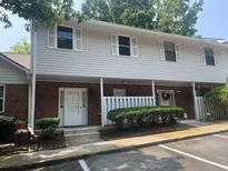 Townhouse with a covered porch, brick facade, light siding, and white trim at 5950 Wintergreen Rd, Norcross, GA 30093