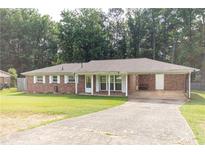 Traditional brick ranch-style home with a concrete driveway and lush lawn at 3829 Bright Star Road Rd, Douglasville, GA 30135