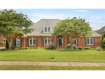 Charming brick home featuring a well-manicured lawn, arched entry, and well maintained landscaping at 718 First Cotton Dr, Powder Springs, GA 30127