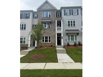 Charming townhome with brick and painted facade, landscaped front yard, and inviting entryway at 1956 Deco Dr, Kennesaw, GA 30144