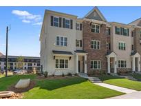 Charming townhome boasts a brick and painted brick facade, a well-manicured lawn, and welcoming curb appeal at 1956 Deco Dr, Kennesaw, GA 30144
