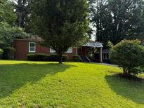 Charming single-story brick home with a well-manicured lawn and mature trees providing ample shade at 186 W Lake Nw Dr, Atlanta, GA 30314