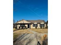 Charming single-story home with well-maintained lawn and inviting curb appeal on a sunny day at 415 Dove Ln, Social Circle, GA 30025