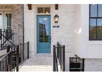 Charming light blue front door with glass panes, black lantern, and brick facade at 530 Fisher Dr # 45, Alpharetta, GA 30009