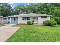 Charming single-story home featuring a lush green lawn, mature trees, and a welcoming front porch at 2756 Gresham Se Rd, Atlanta, GA 30316