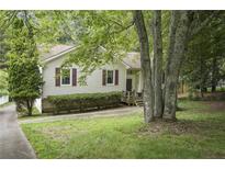Charming one-story home with light-colored siding, red shutters, and mature landscaping at 291 N Briar Rdg, Woodstock, GA 30189