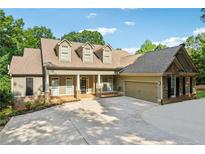 Charming exterior elevation showcasing the home's craftsman design and well-manicured landscaping at 148 Copper Hills Dr, Canton, GA 30114