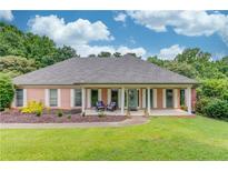 Charming brick home with a covered porch, white columns, and manicured front lawn at 2005 Ashton Pointe Dr, Dacula, GA 30019