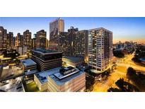 Stunning dusk aerial view of buildings in an urban setting with lights illuminating the city at 215 Piedmont Ne Ave # 2208, Atlanta, GA 30308