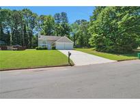 Charming single-Gathering home with a well-manicured lawn and attached two car garage at 4879 Ardsley Dr, Lithonia, GA 30038