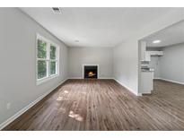 Bright living room featuring wood floors and a cozy fireplace at 3919 Valley Brook Rd, Snellville, GA 30039
